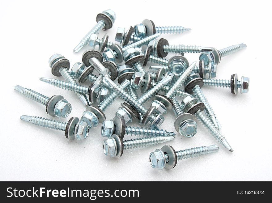 Set of screws scattered on a white background