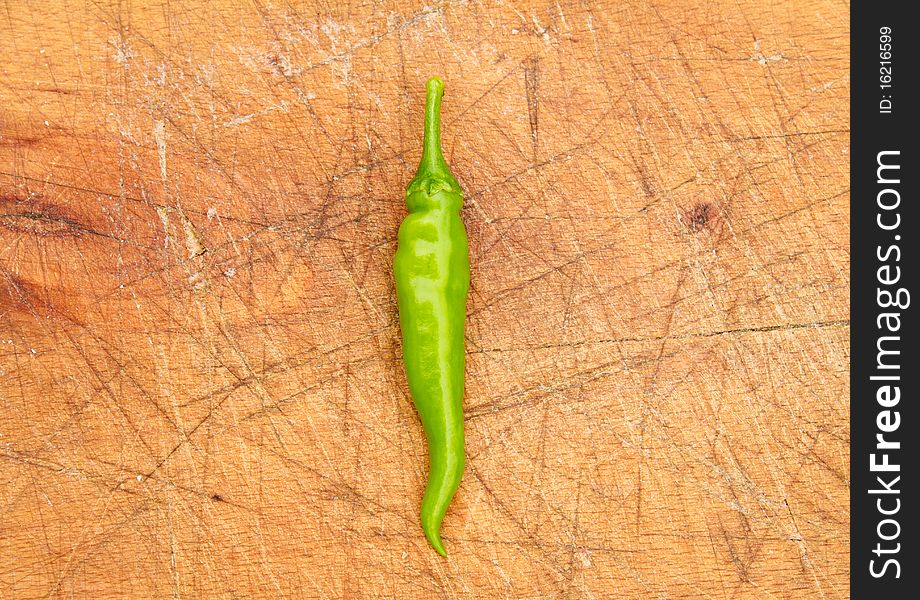 Green chilli pepper on a cutting board