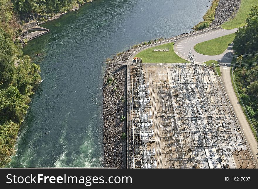 The river beside a large power plant below a dam. The river beside a large power plant below a dam.