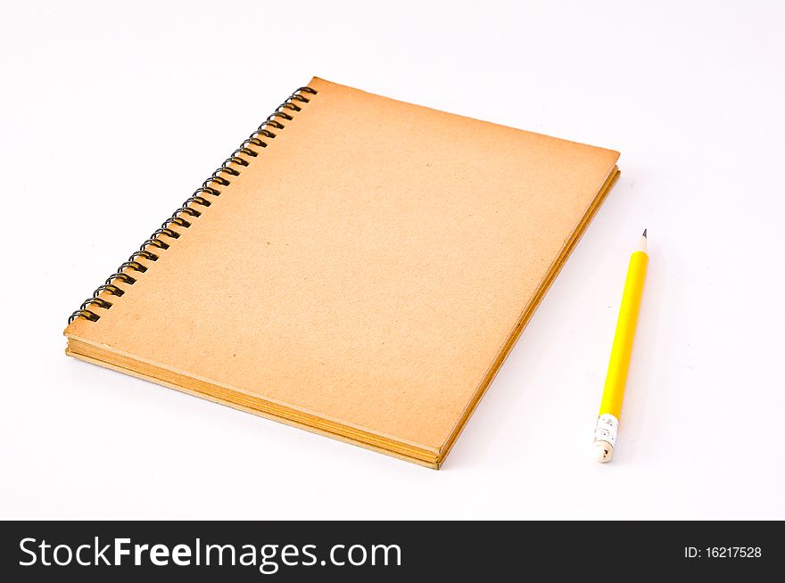 Brown Spiral Notebook with yellow pencil