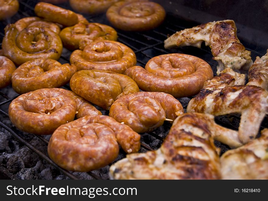 Chicken wings and sausages on the grill. Chicken wings and sausages on the grill.
