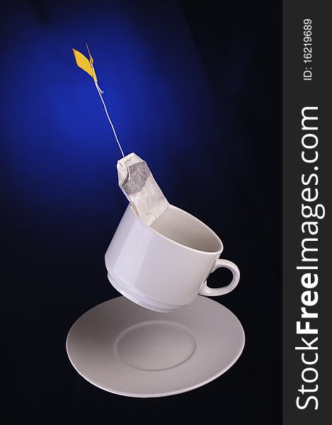 Tea bag and teacup on a dark blue background