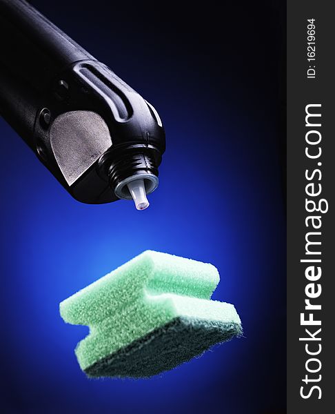 Detergent and sponge on a dark blue background