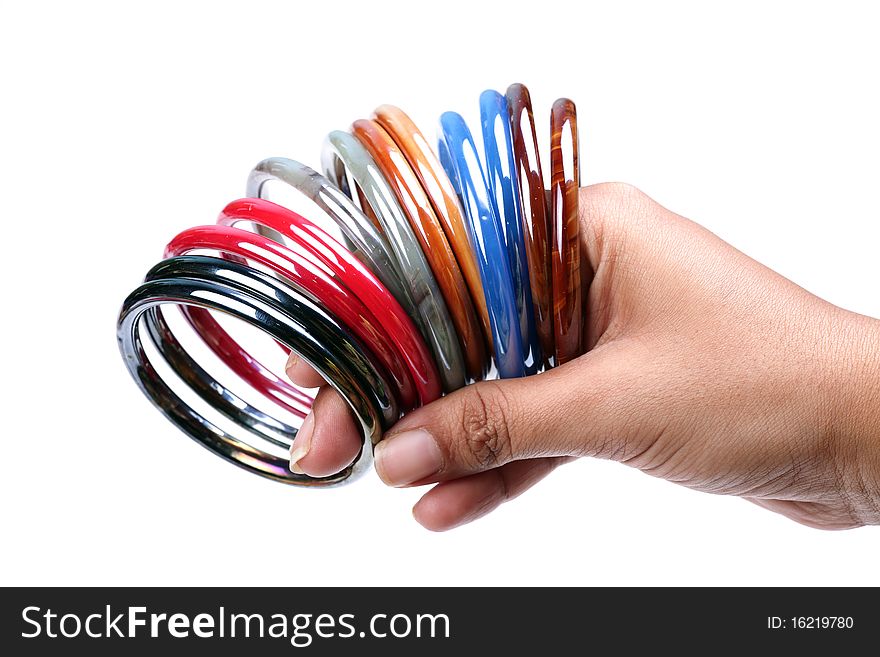 Female hand holding glass bangles on white background.