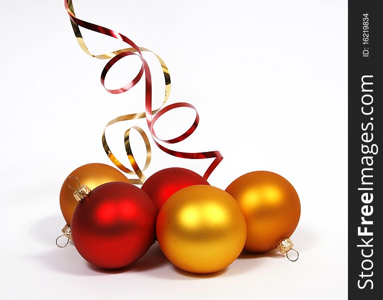Yellow and red glass balls with ribbons on the white background. Yellow and red glass balls with ribbons on the white background