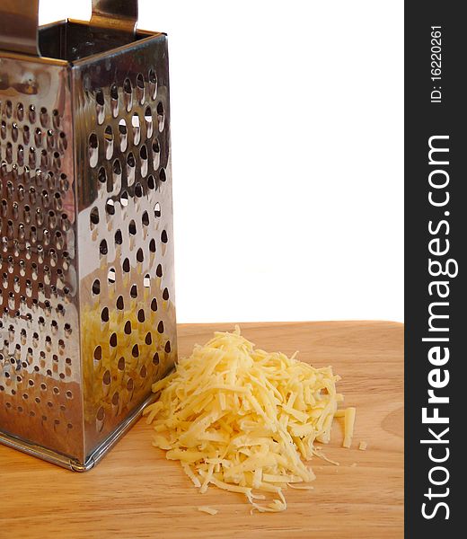 A handful of grated cheese on a wooden cutting board