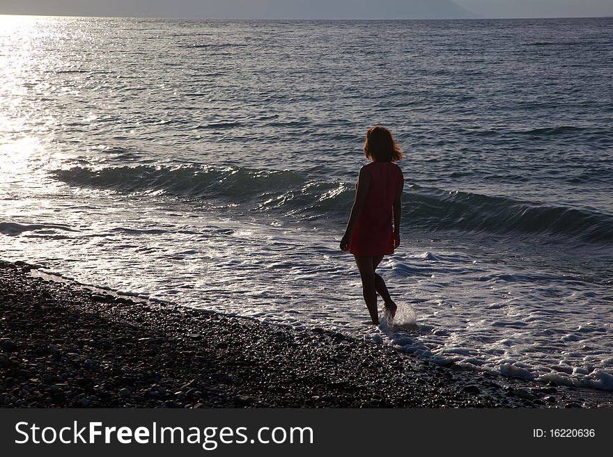 Girl walking on the beach at sunset. Girl walking on the beach at sunset