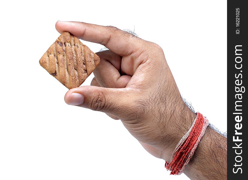Male hand holding chocolate chip cookie on white background.