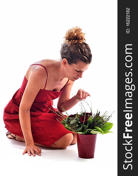 Beautiful woman arranging flowers in front of a white background. Beautiful woman arranging flowers in front of a white background