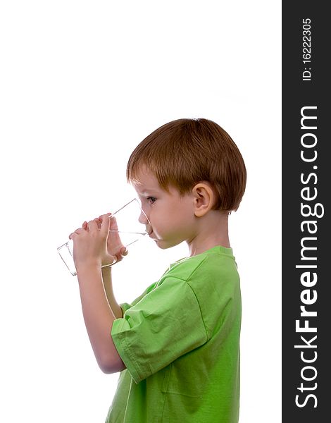 Boy drinks water from a glass on a white background