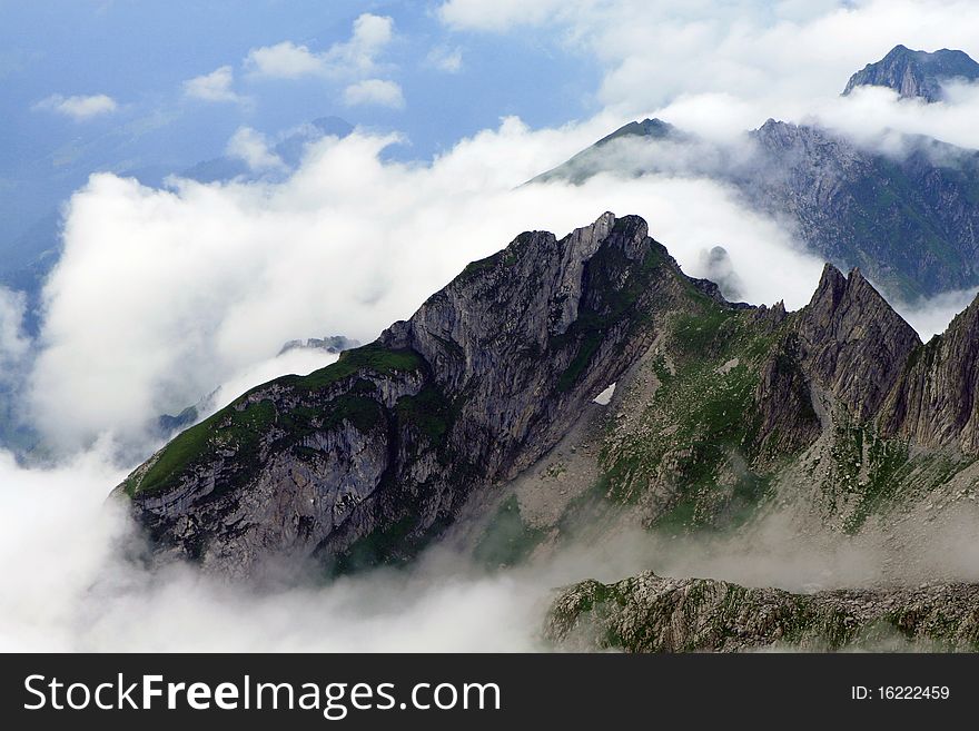 A cloud-swept mountain view in the Alpine mountains in Switzerland. A cloud-swept mountain view in the Alpine mountains in Switzerland