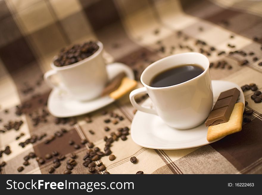 Two coffee cups on table, second one blurred in background. Two coffee cups on table, second one blurred in background