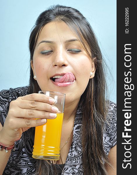 Indian female model drinking orange juice. Indian female model drinking orange juice.