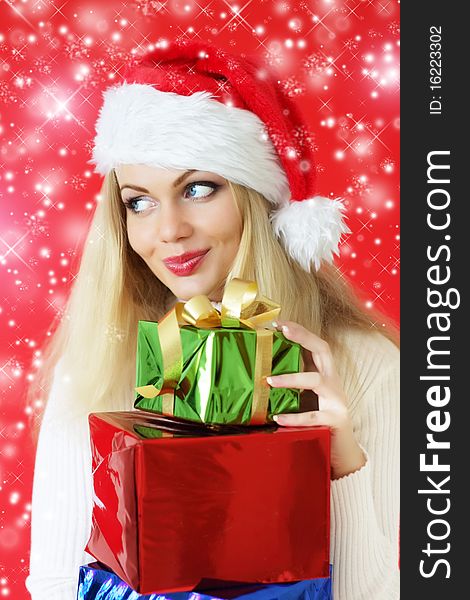 Santa girl holding gifts on a red background