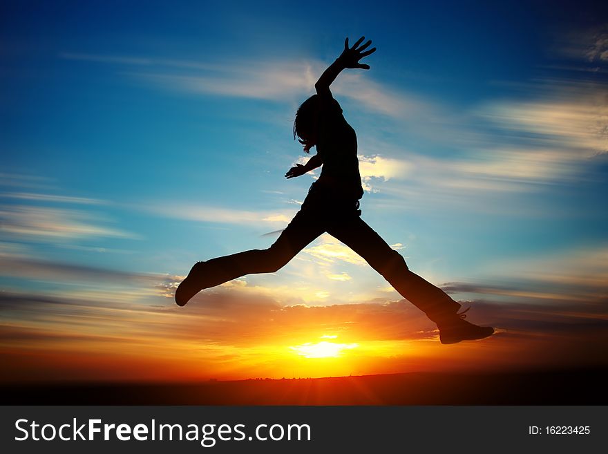 Young woman jumping with raised hands
