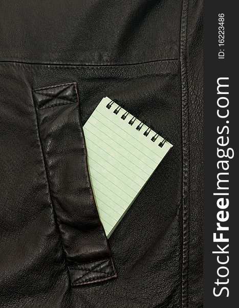 A notebook is in a leather pocket