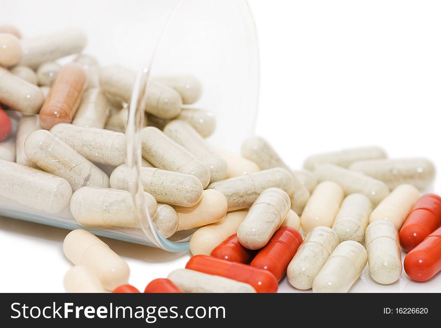 Pills in a glass isolated on white background