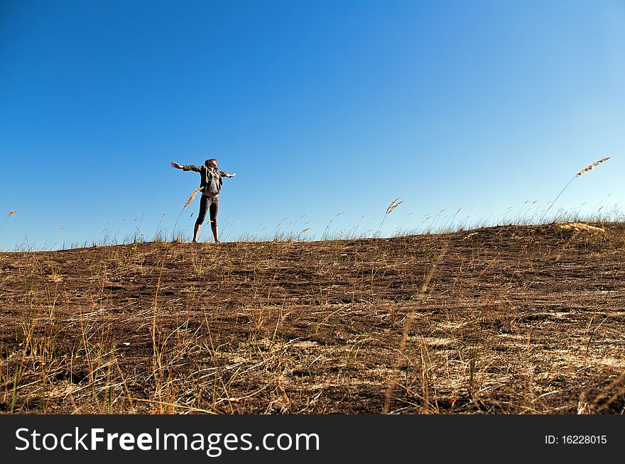 A beautiful young woman experiencing freedom or good time among dunes in the recent warm days of autumn. A beautiful young woman experiencing freedom or good time among dunes in the recent warm days of autumn