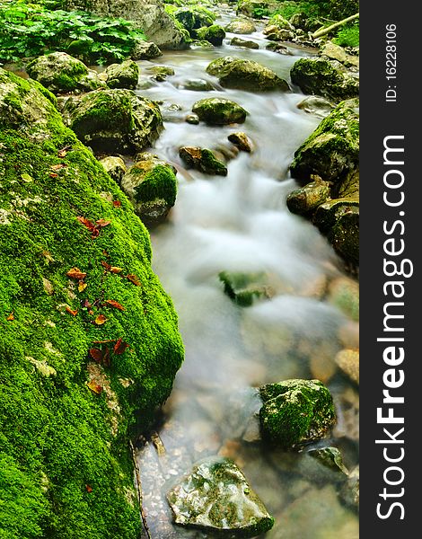 Beautiful mountain river streaming between mossy stones. Beautiful mountain river streaming between mossy stones