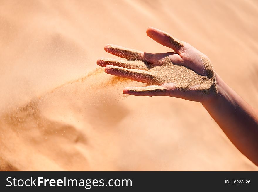 Sand is falling from girl's arm. Sand is falling from girl's arm