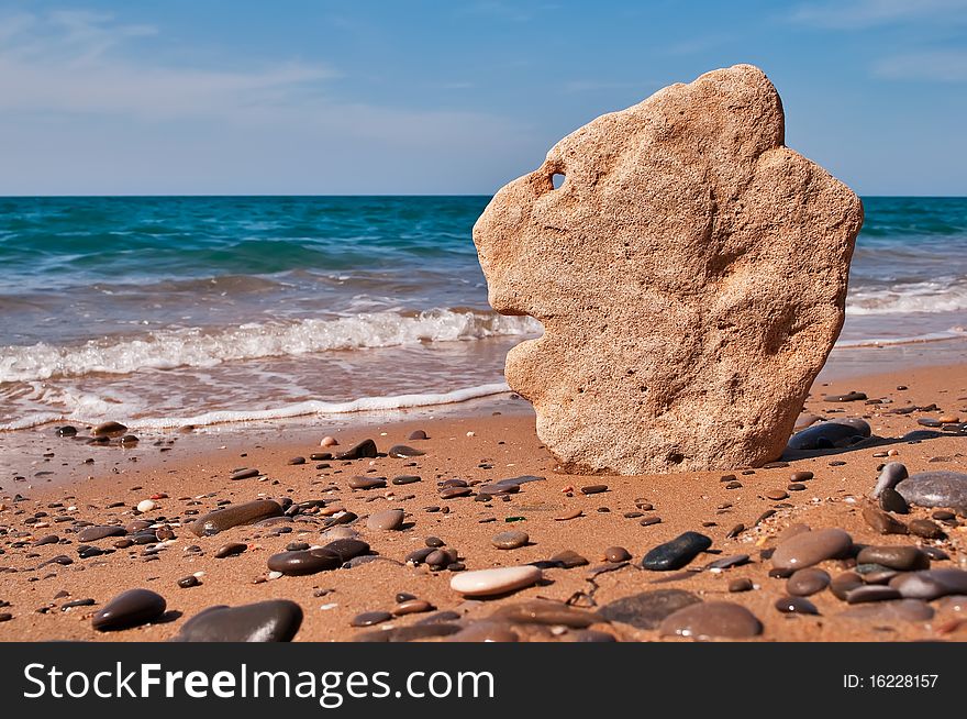 Stone in the shape of the head of a lion on a background of sea. Stone in the shape of the head of a lion on a background of sea