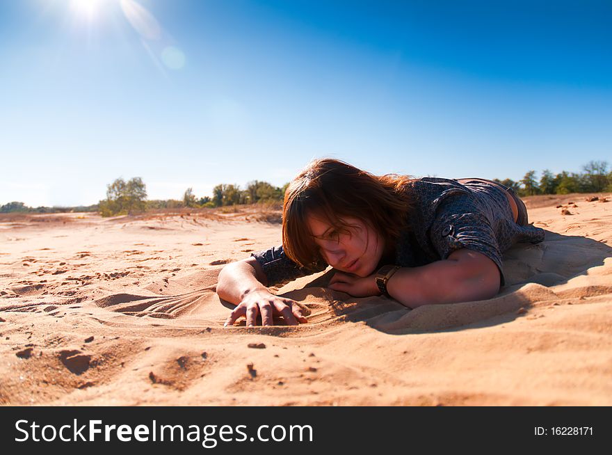 The girl sits on sand and enjoys the nature. The girl sits on sand and enjoys the nature