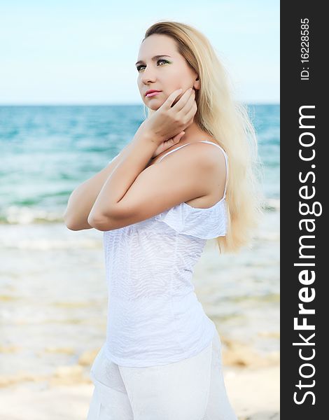 Young beautiful woman posing near the ocean. Young beautiful woman posing near the ocean