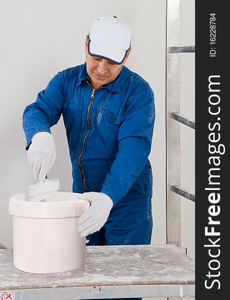 Construction senior  worker mixing paint. Construction senior  worker mixing paint