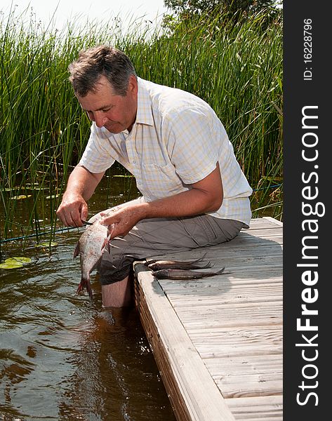 Senior Man Scaling Fish