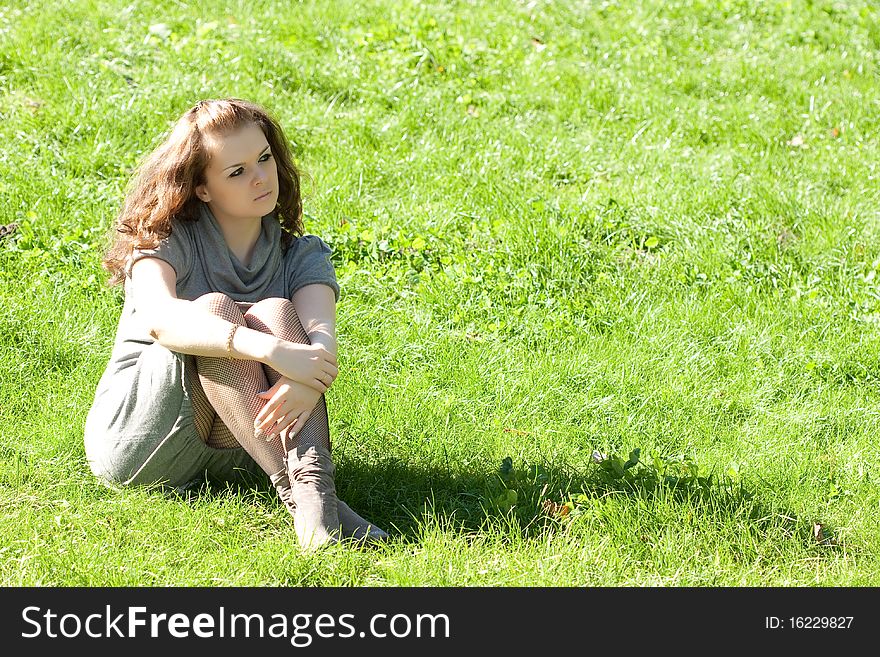 Girl sitting on green grass