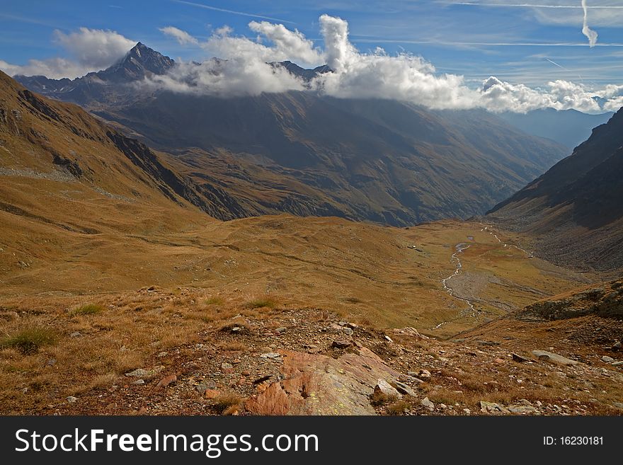 Alpin wetland at 2615 meters on the sea-level. Top of the Valle delle Messi, Brixia province, Lombardy region, Italy. Pietra Rossa Pass (2890 meters on the sea-level) as background