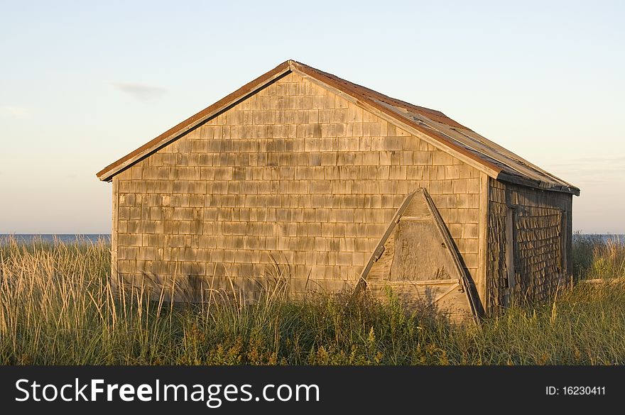 Wooden shed with a wood boat leaning against it