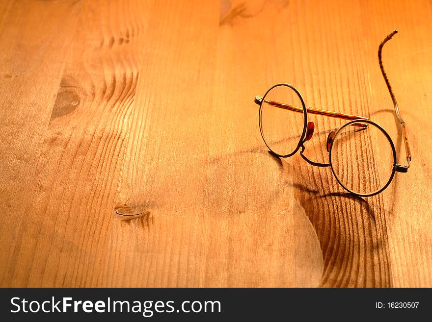 Vintage spectacles lying on nice yellow wooden background. Vintage spectacles lying on nice yellow wooden background