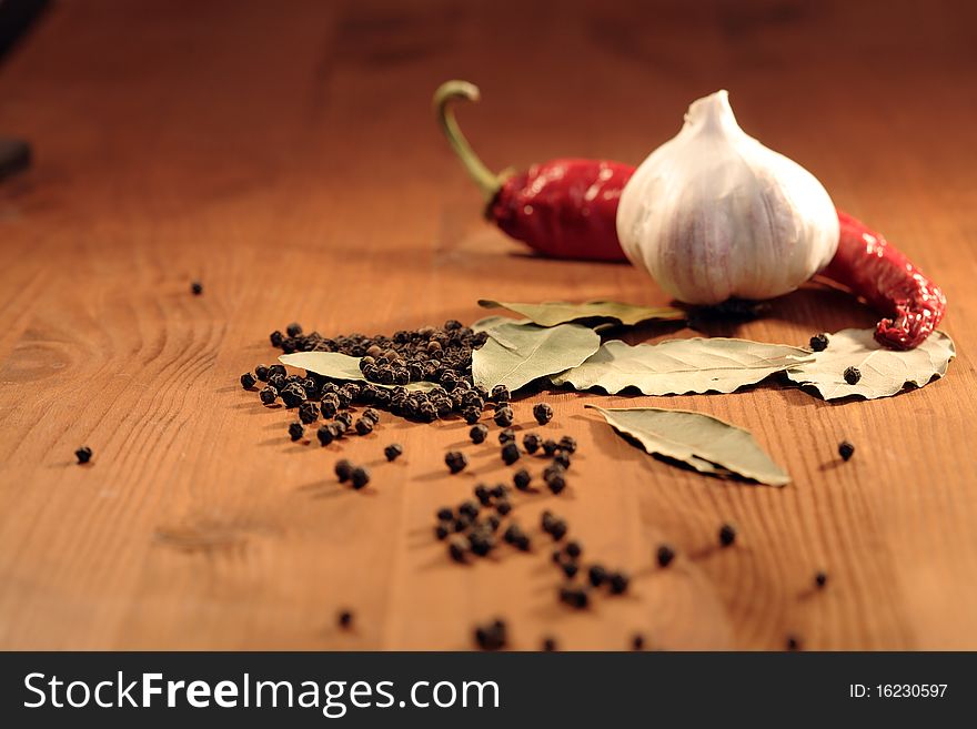 Bay leaves, head of garlic and peppercorns on wooden background. Bay leaves, head of garlic and peppercorns on wooden background