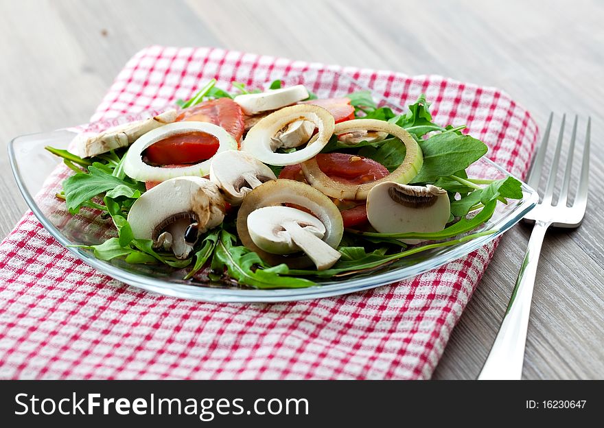Salad with arugula and fungi on plate