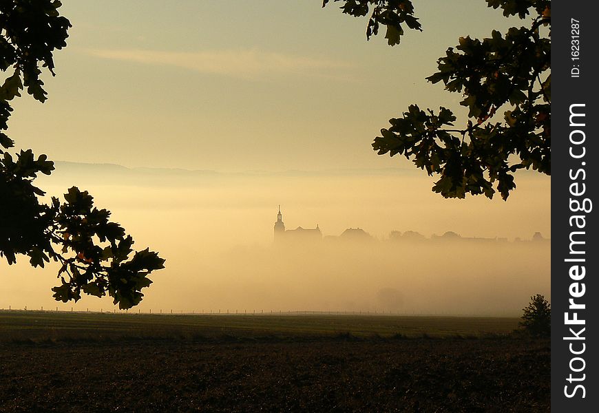 Church in the fog with a tree in the foreground