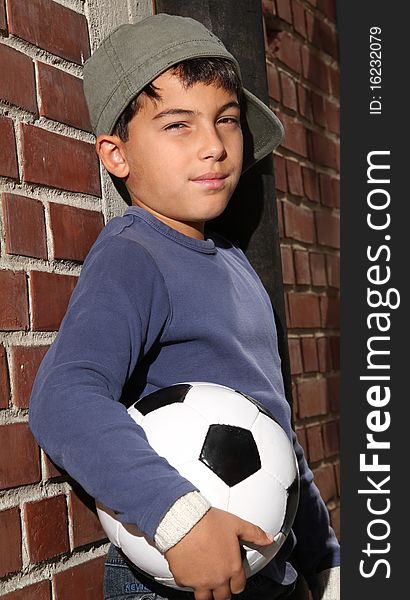 Male kid standing outside with a football. Male kid standing outside with a football