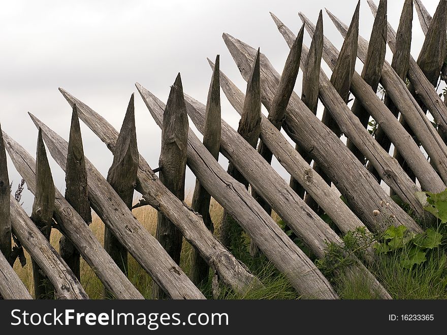 The reconstructed fortifications at Dybboel Banke in Denmark. Close-up wooden palisades all over. The reconstructed fortifications at Dybboel Banke in Denmark. Close-up wooden palisades all over.