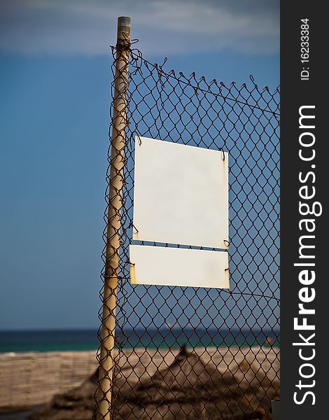 Two plates on a fence against a sea beach