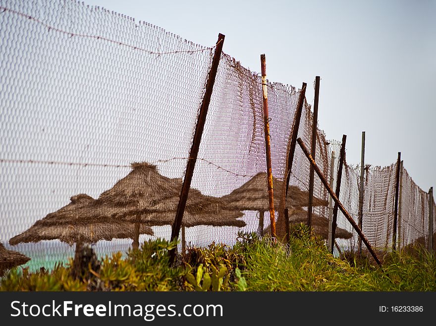 Fence from a rusty metal grid against a sea beach