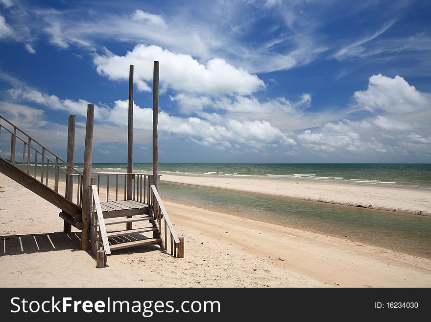 Wood bridge to the sea with blue sky