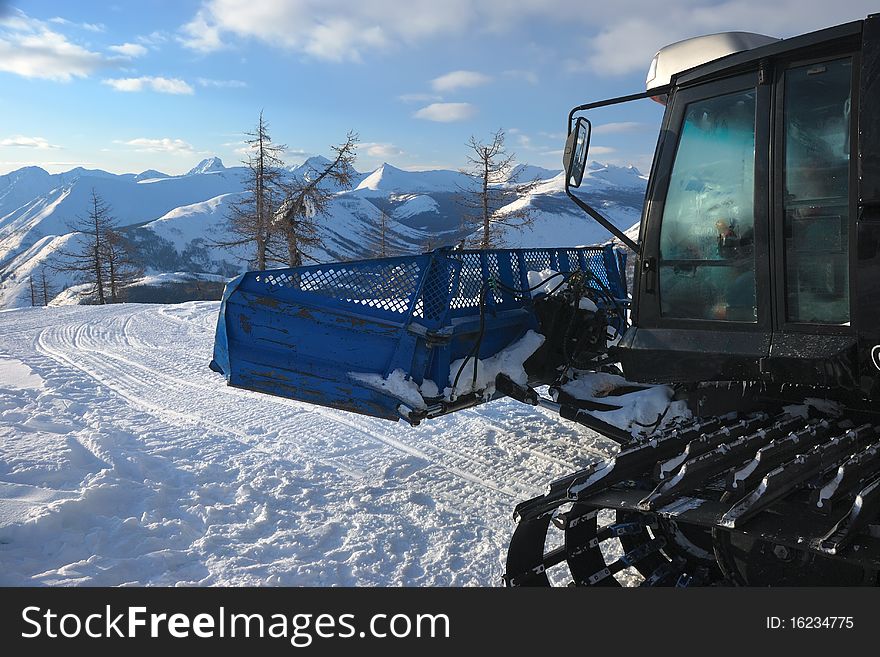 Snowcat In Mountains In The Evening