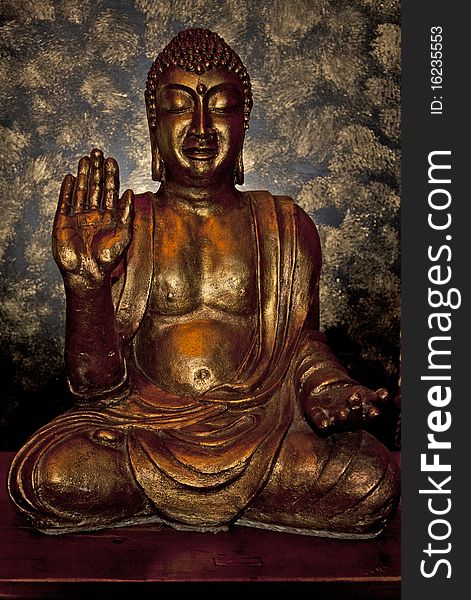 A golden buddha icon statuette backlit. A golden buddha icon statuette backlit