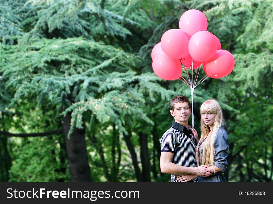 Young loving couple with red balloons