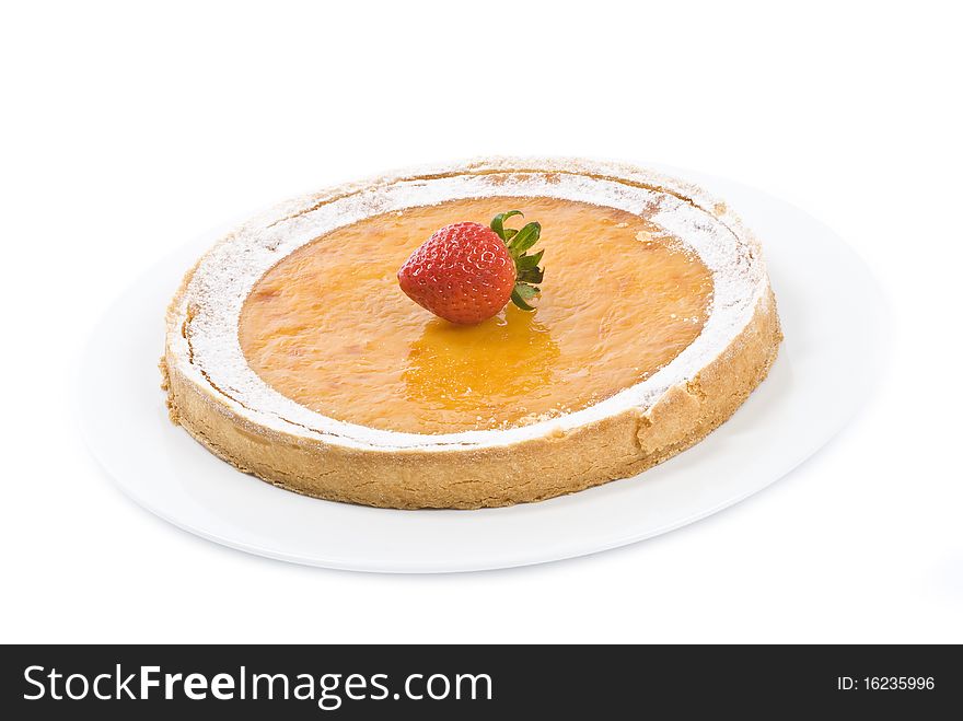 A fancy lemon tart on a white plate, decorated by one strawberry, on white. A fancy lemon tart on a white plate, decorated by one strawberry, on white.