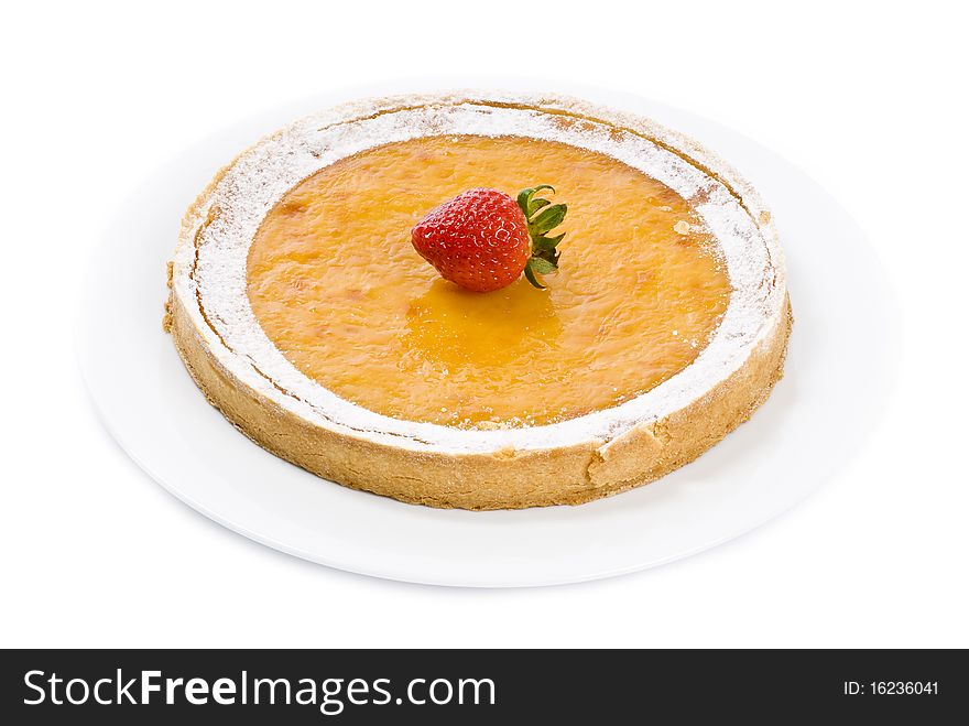 A fancy lemon tart on a white plate, decorated by one strawberry, isolated on white. A fancy lemon tart on a white plate, decorated by one strawberry, isolated on white.