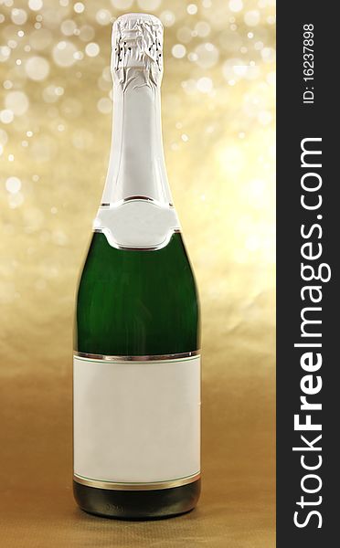 Studio photo of bottle with champagne on gold background. Studio photo of bottle with champagne on gold background