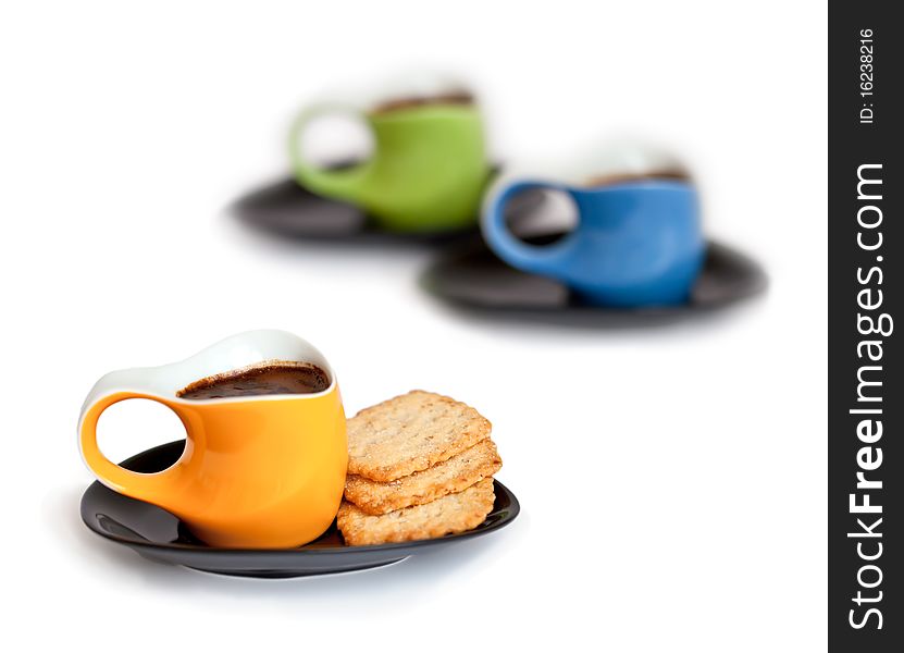 Three small colorful coffee cups with cookies isolated on white background. Three small colorful coffee cups with cookies isolated on white background
