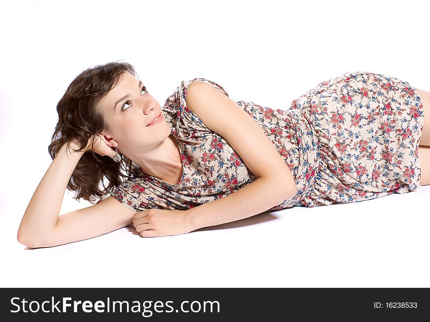 Young woman lying on the floor. White background. Studio shot. Young woman lying on the floor. White background. Studio shot.