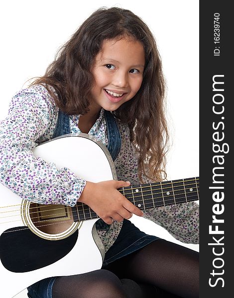 Girl plays the guitar, portrait of a child with music instrument before white background